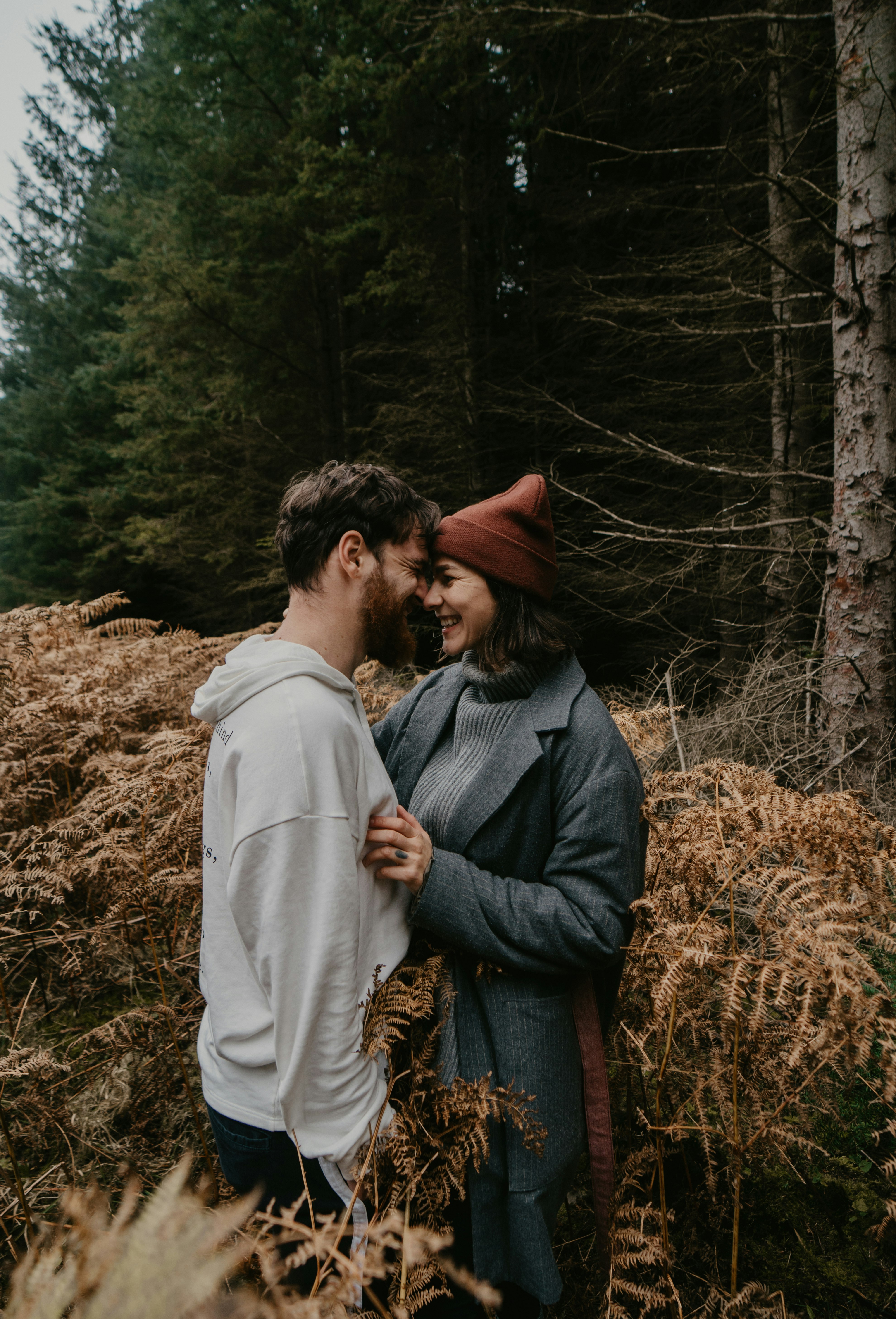 man and woman kissing on brown grass field during daytime